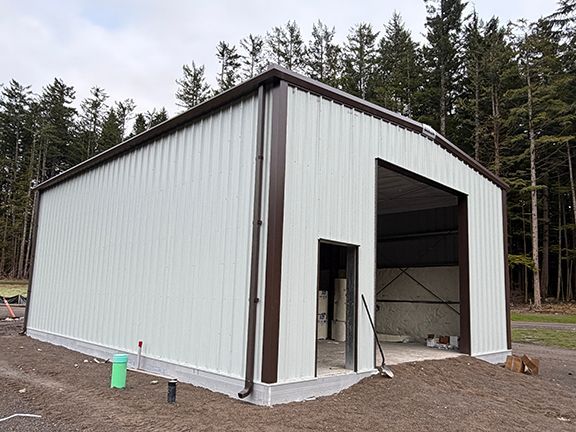 Metal building project in Squamish, British Columbia showcases white wall panels and brown trim.