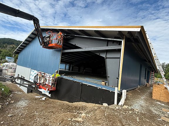 Crane adds insulated metal panels to side of commercial building project.
