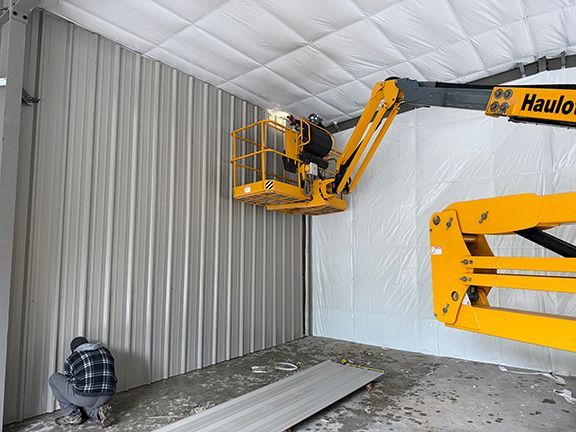 Experienced crew fastens wall panels with help of elevator.