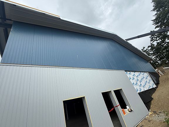 Grey and blue metal wall panels waiting for windows to be added.