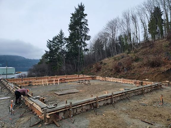 A man is working on the foundation of a house.