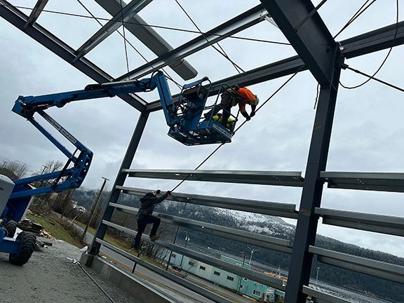 A man is standing on a lift working on a building.