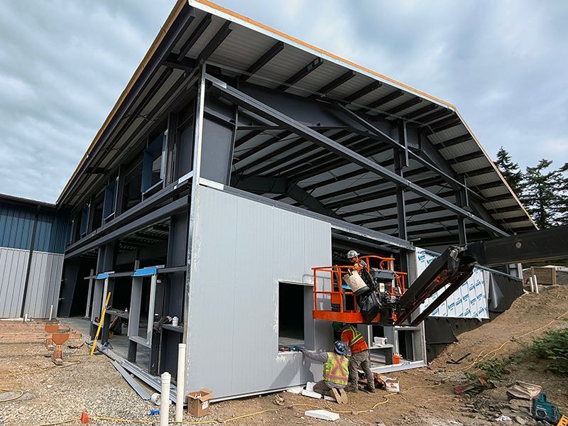 Skilled tradespeople add first wall panel to building project on Salt Spring Island, BC.
