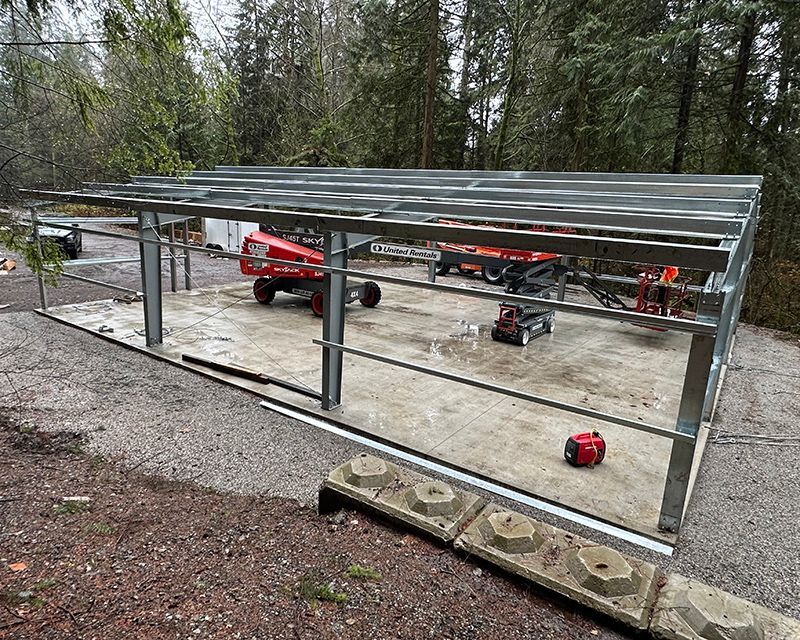 A metal structure is being built in the middle of a forest.