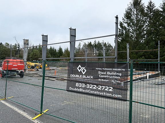 DBC banner stands in front of pre-engineered building framing.