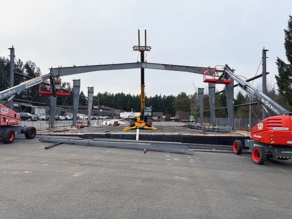 Front view of steel crossbeams being added to industrial building.