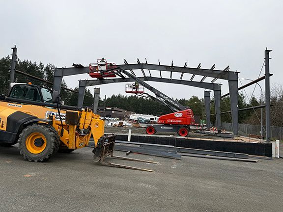 Qualified team of construction workers adds purlins to new building.