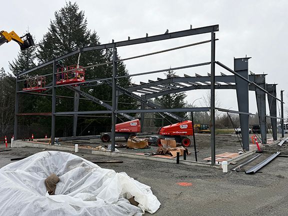 Cranes add more steel framing to an industrial building project for VMAC in Nanaimo.