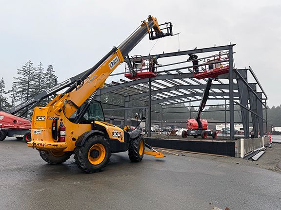 Double Black Construction team uses a crane to add for metal framing for VMAC building project.