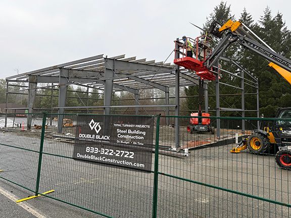 Cranes add final purlins to steel framing for industrial building in Nanaimo.