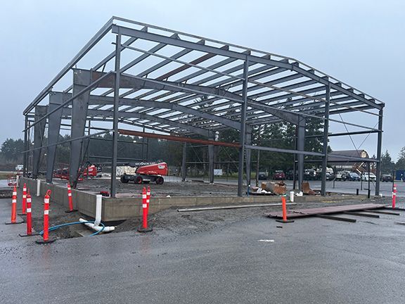 Steel building framing for a large workshop structure under construction.