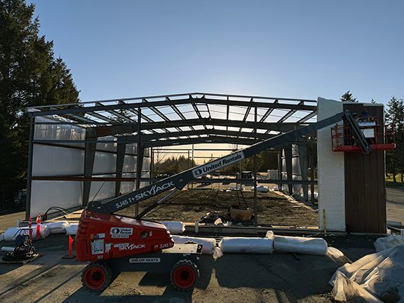 Front view of brown metal panels being installed on workshop building in Nanaimo.