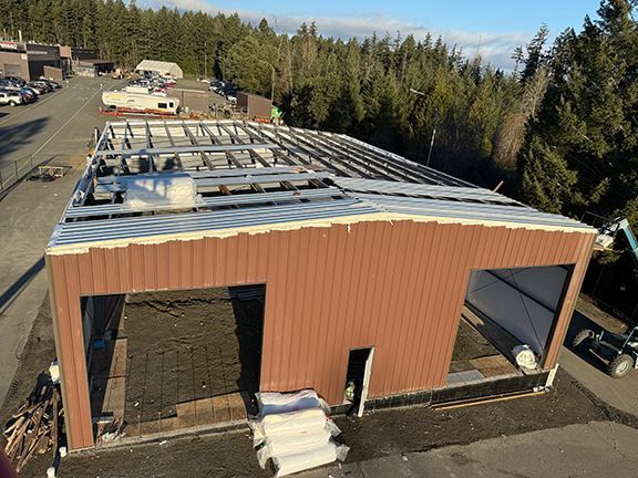 Top view of metal building under construction in BC that shows roofing system and supports.