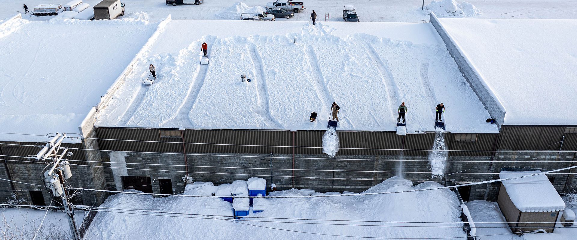 Workers shovel a snow covered roof in Anchorage, Alaska.