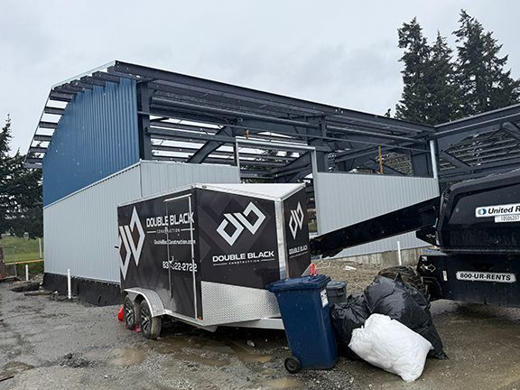 Double Black Construction led by John Lohan adds steel wall panels at construction site.