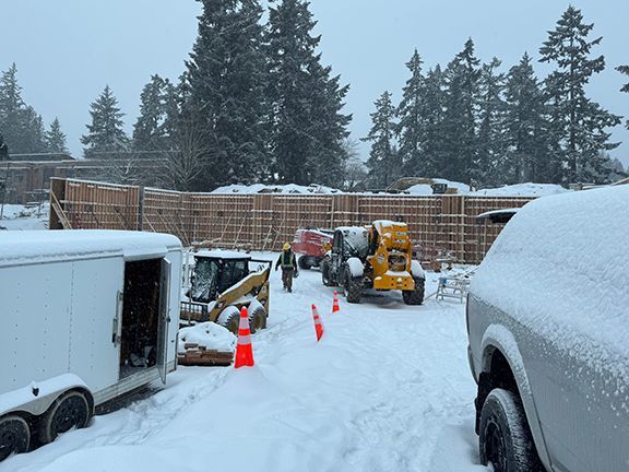 Snowfall on construction site in British Columbia showing wood forms in place.