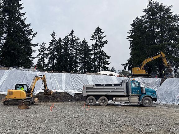 Trucks helping to excavate a construction site on Salt Spring Island, BC for Double Black Construction.