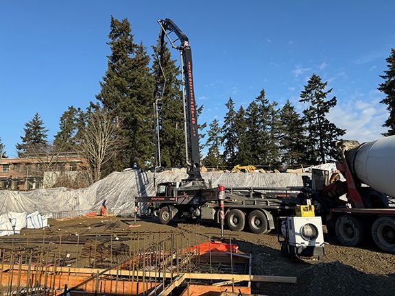 Crane and concrete truck on jobsite for Double Black Construction project.