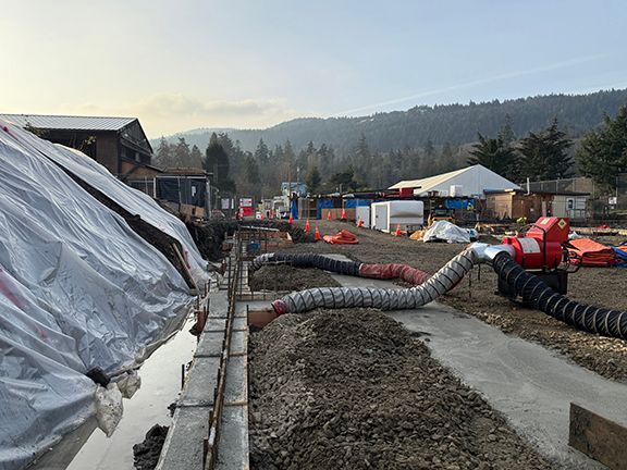 Concrete base being added to perimeter of building site in advance of wooden forms.