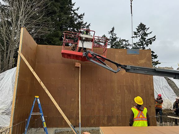 Wood wall form being added to construction site on Salt Spring Island.