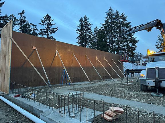 Wooden frame and plywood being added where concrete retaining wall will be poured later.