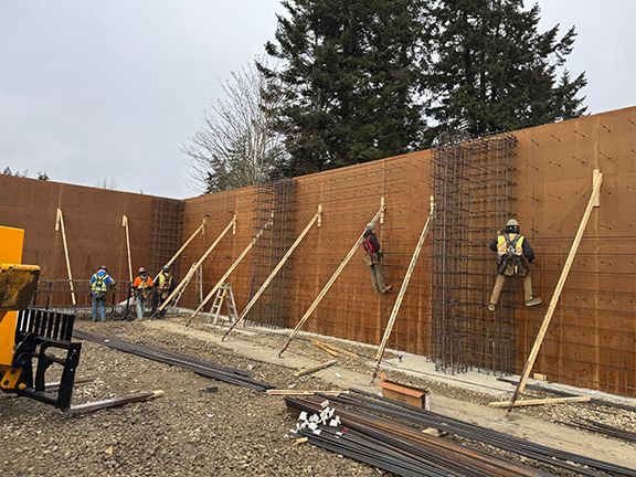 Skilled tradespeople at supporting rebar to reinforce wood forms on Salt Spring Island, BC jobsite.