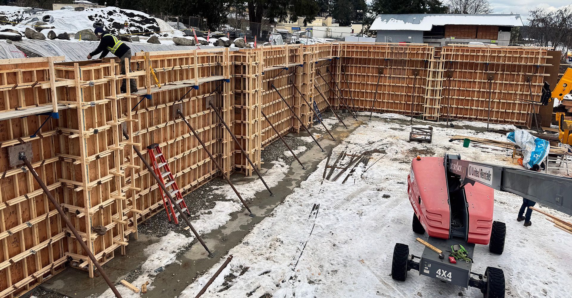 Wooden forms are installed on jobsite to create strong concrete retaining wall for metal building.