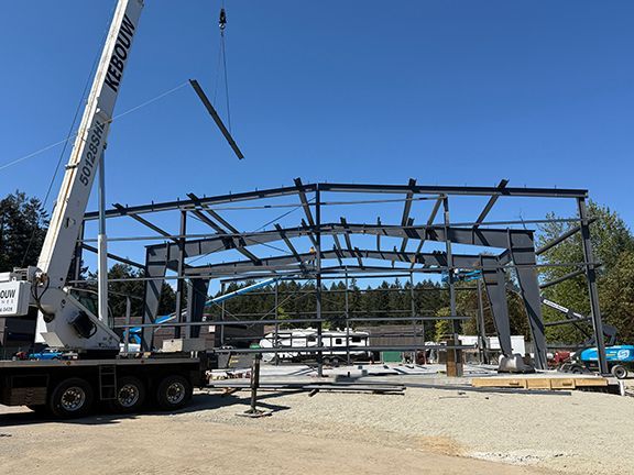 Construction team lowers steel I-beams into place