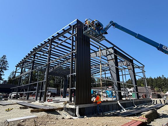 Steel wall panel being added at Double Black Construction erector site.