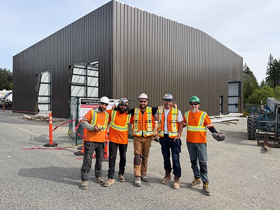 Double Black Construction team of skilled tradespeople in front of metal building