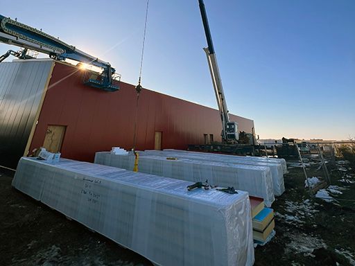 A crane is lifting a stack of boxes on a construction site.