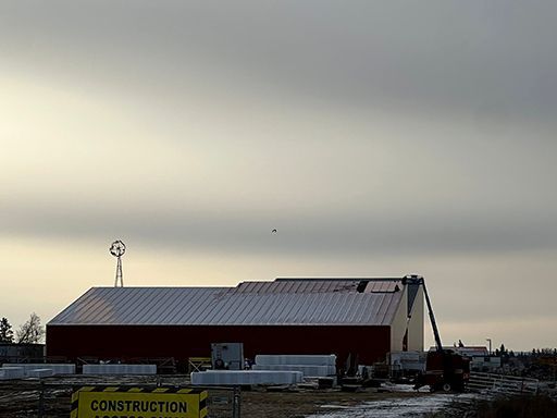 A construction sign is in front of a building under construction.