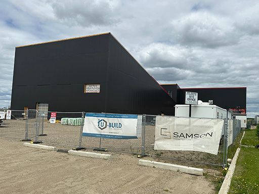 A large building with a fence around it is being built.