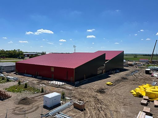 An aerial view of a building under construction with a red roof.