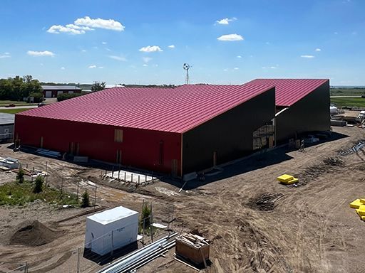 An aerial view of a large building under construction with a red roof.