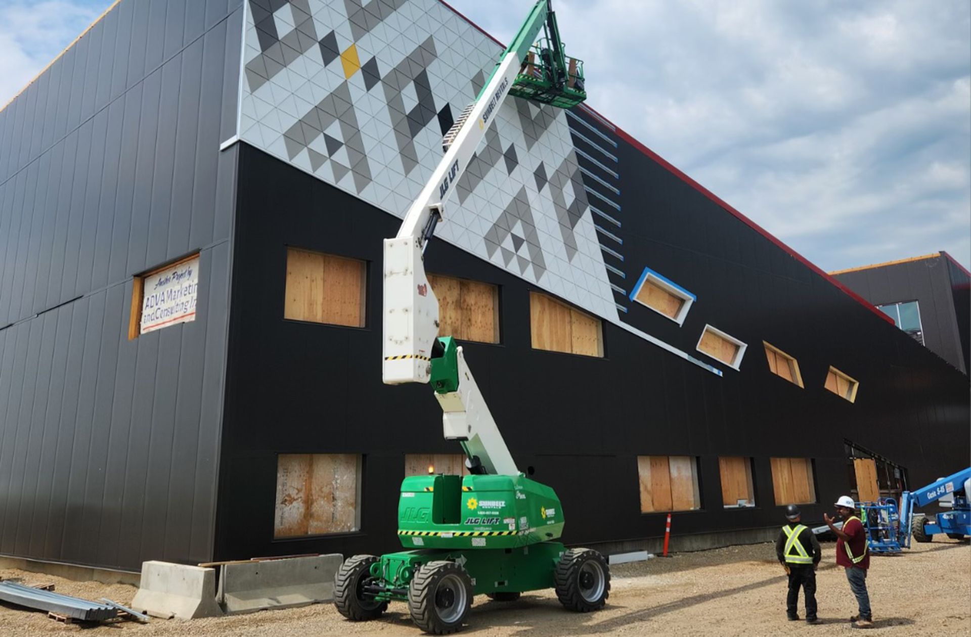 Team of skilled tradespeople installing decorative panels on a PEB.