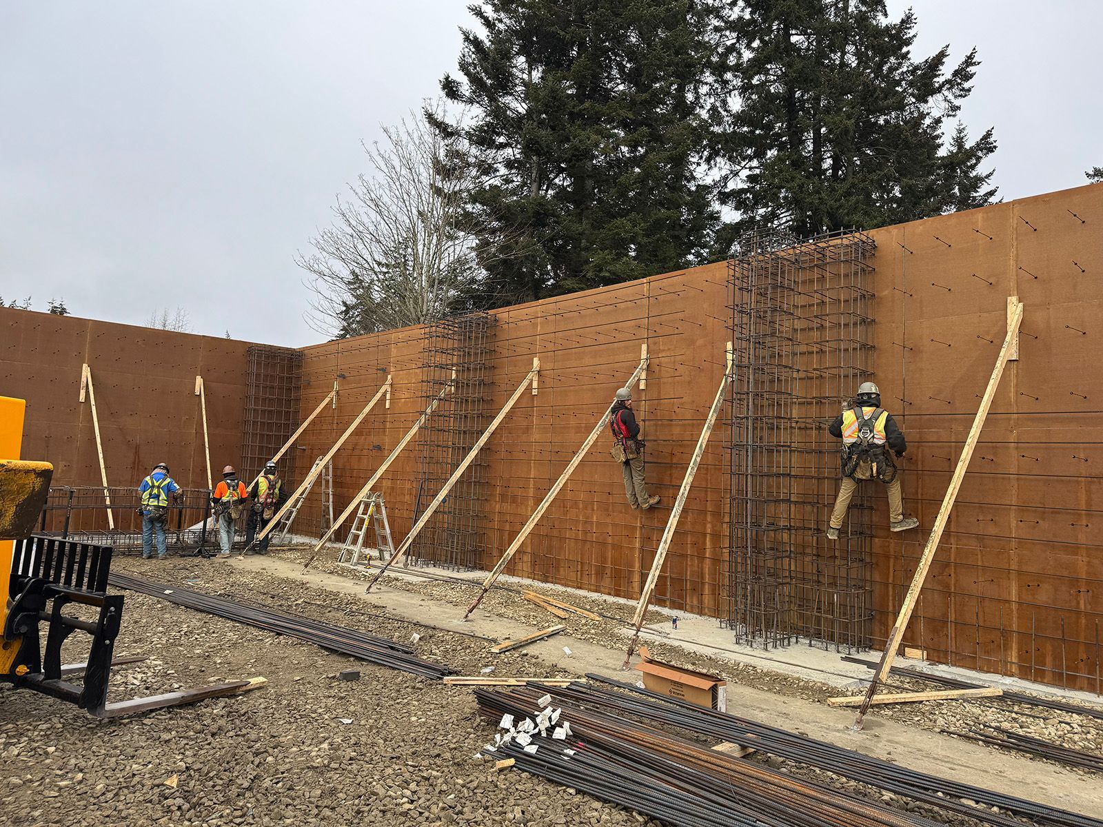 Skilled workers add rebar supports to wood forms.