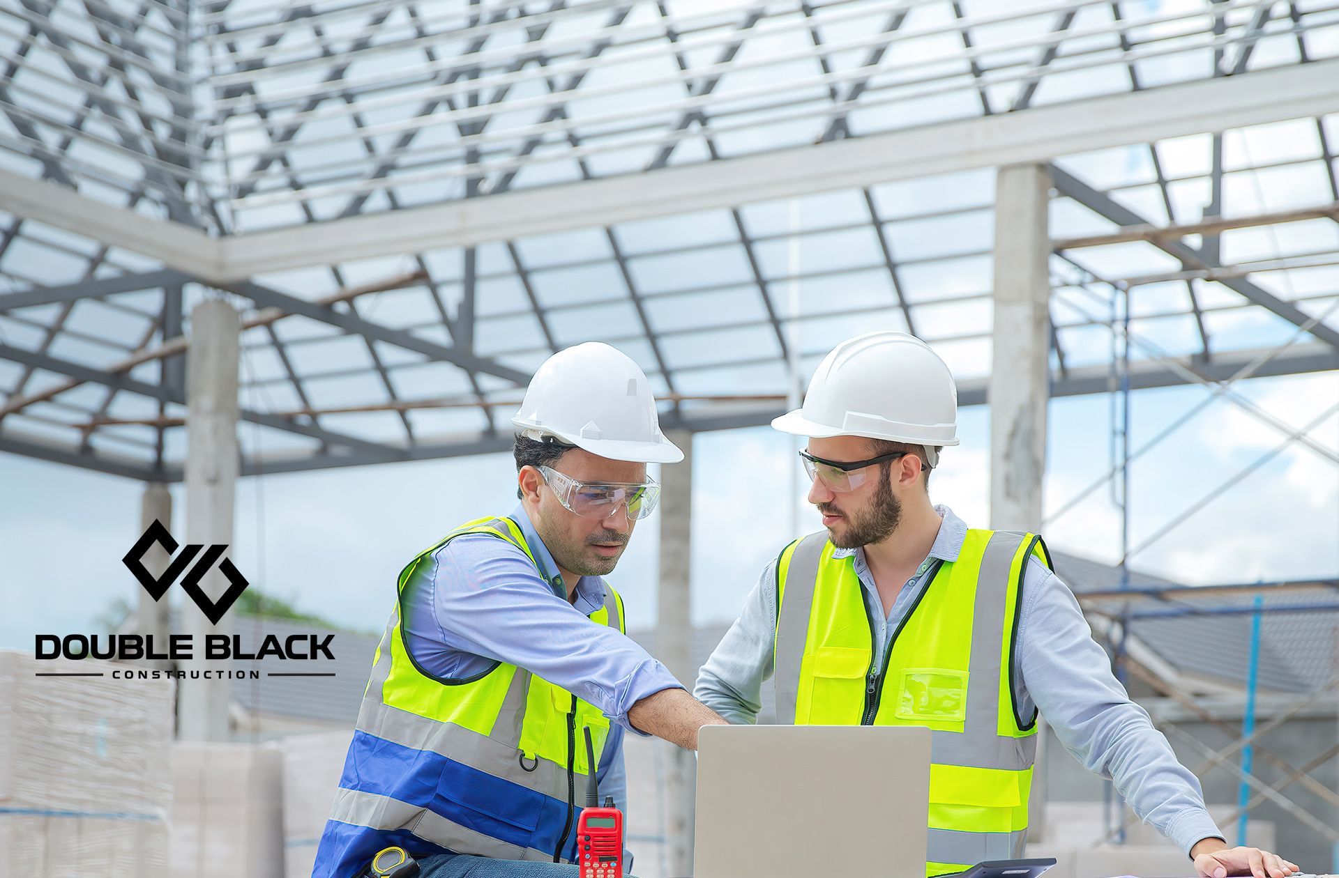Two engineers discuss a metal building project under construction.