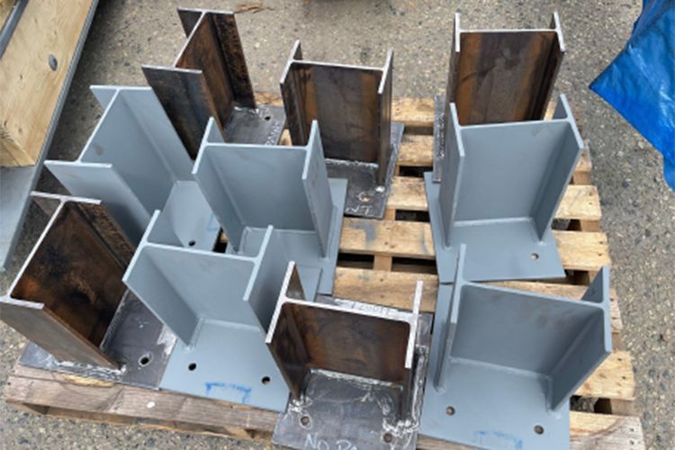 A bunch of metal pieces are sitting on top of a wooden pallet.