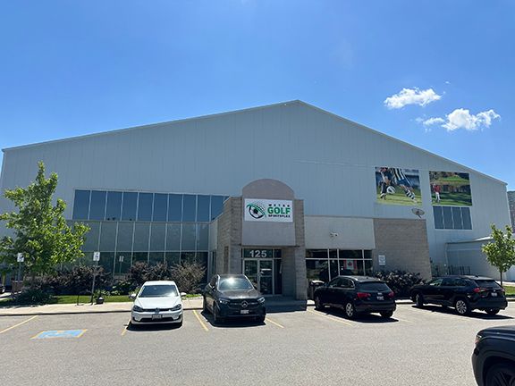 A large white building with cars parked in front of it.