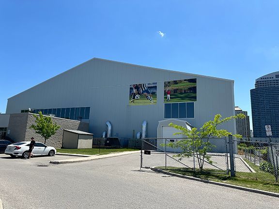 A large white building with a lot of windows and a fence in front of it.