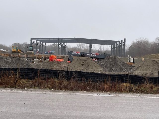 A large building is being built on the side of the road.