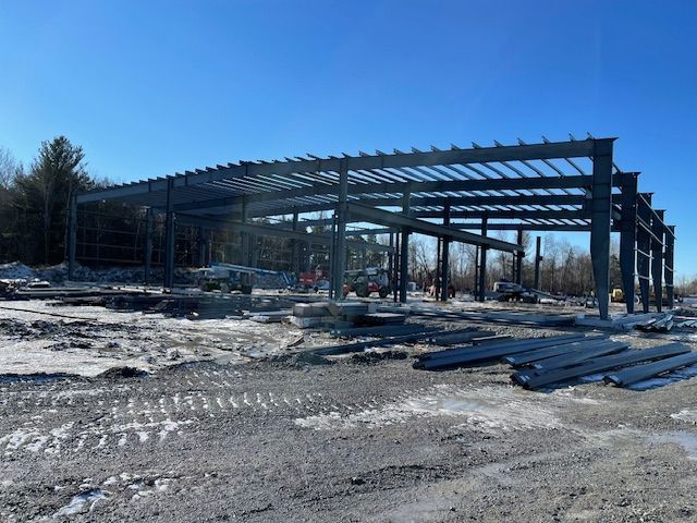 A large metal structure is being built in the middle of a snowy field.