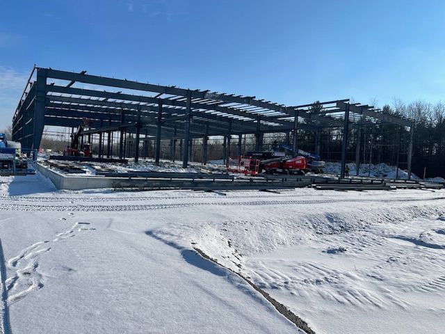 A large metal structure is being built in the snow.