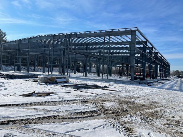 A large metal structure is being built in the snow.