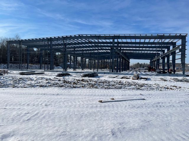 A large metal structure is being built in the snow.