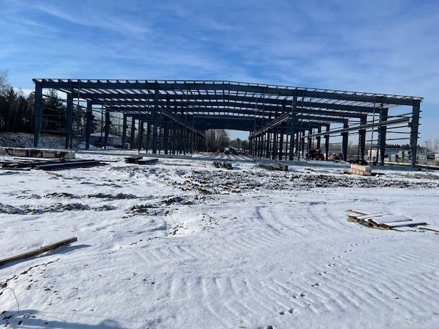 A large metal structure is being built in the snow.