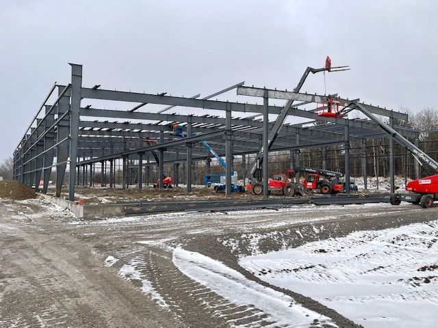 A large metal structure is being built in the snow.