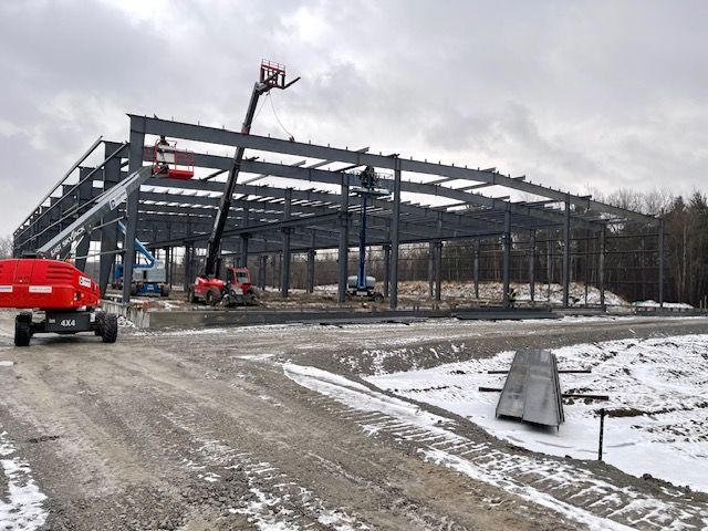 A large metal structure is being built in the snow.