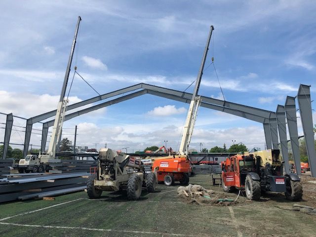 A large metal structure is being built with a lot of machinery.